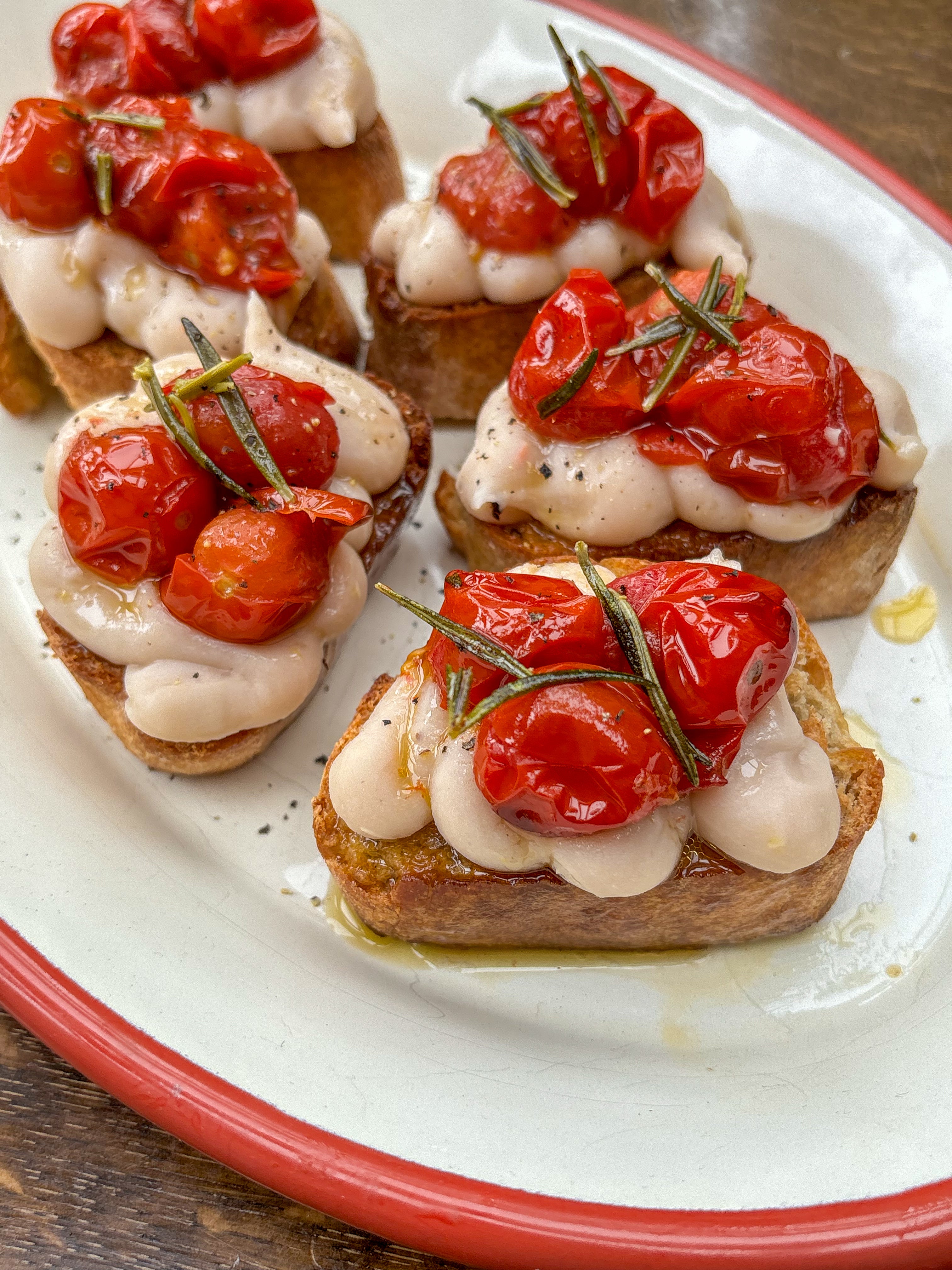 White Bean Crostinis with Confit Garlic + Rosemary Tomatoes